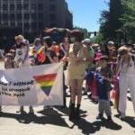 A group of students, staff, and community members walk in the PRIDE parade with SPS.